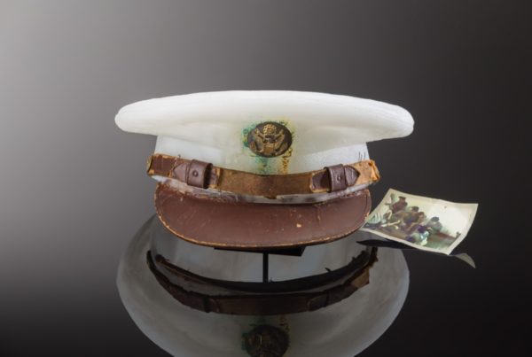Milky white cast glass hat with patina on the emblem and an old photograph