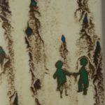 Close-up of a glass panel with small figures of a boy and girl holding hands