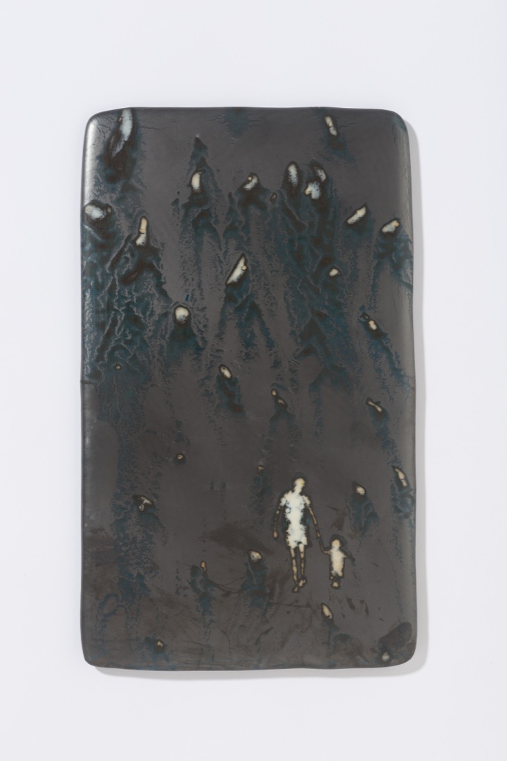 Metallic-looking glass panel with small figures of a child and father holding hands