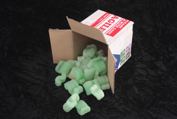 Cardboard box with green cast glass packing peanuts