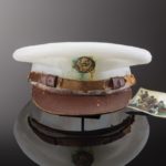 Milky white cast glass hat with patina on the emblem and an old photograph